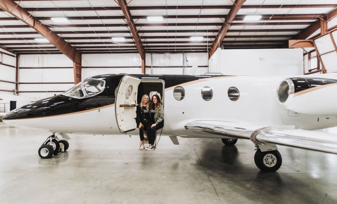 Co-founders seated at the doorway of a private jet