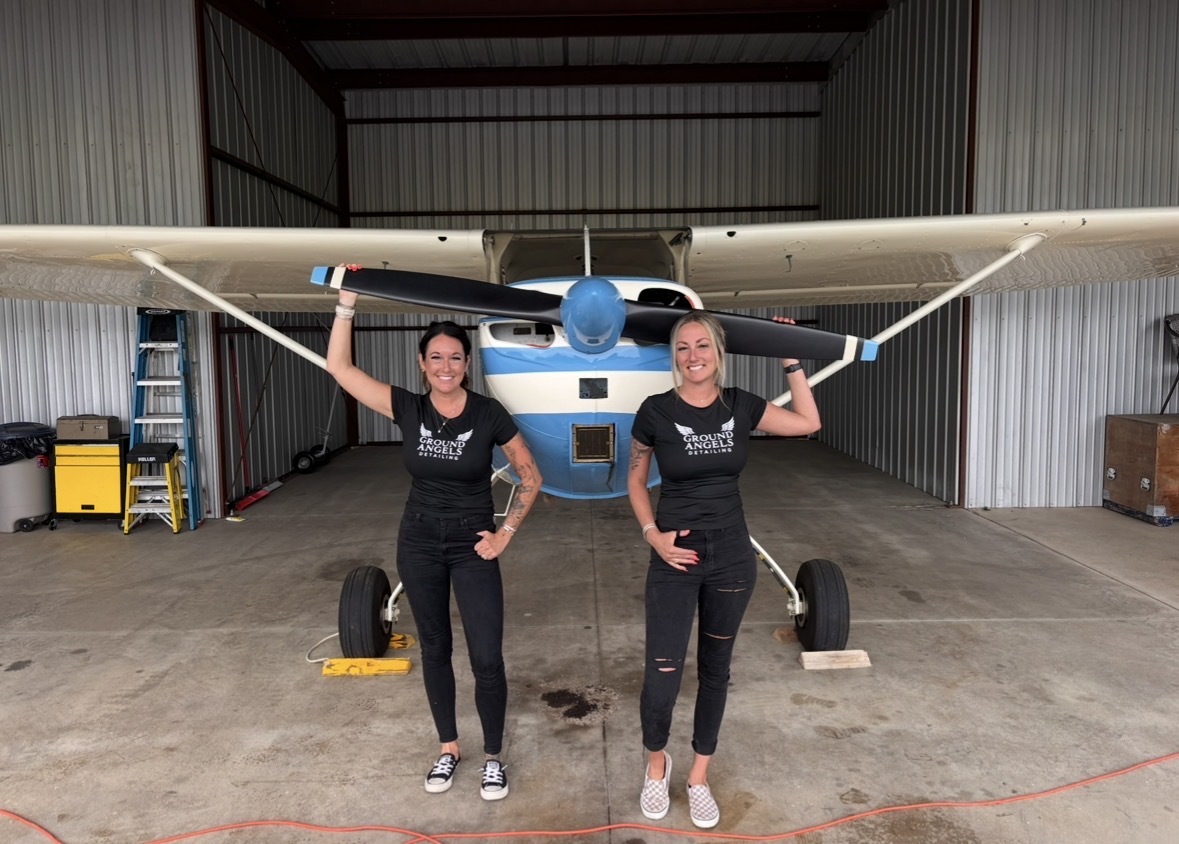 Co-founders in front of a propeller aircraft