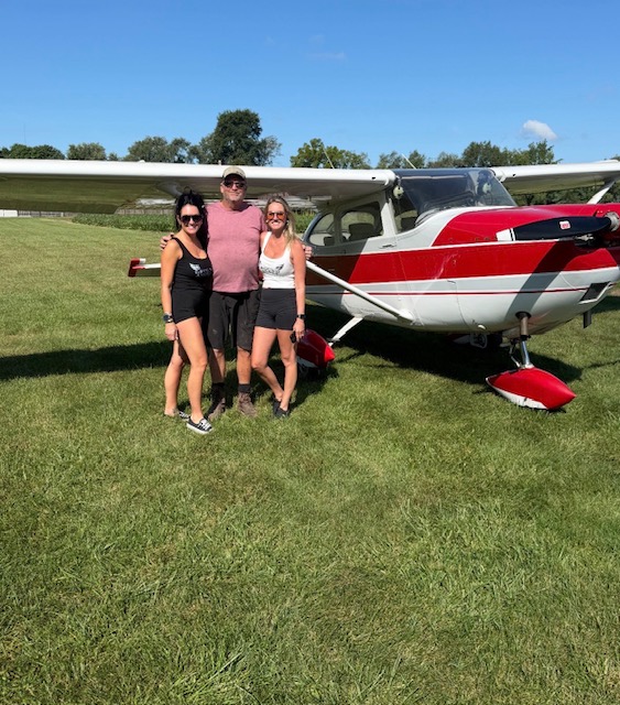 Kristina, Alissa, and a friend in front of a red Cessna